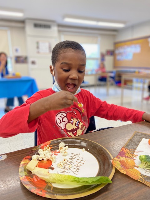 A boy in a PLASP program enjoys a healthy snack