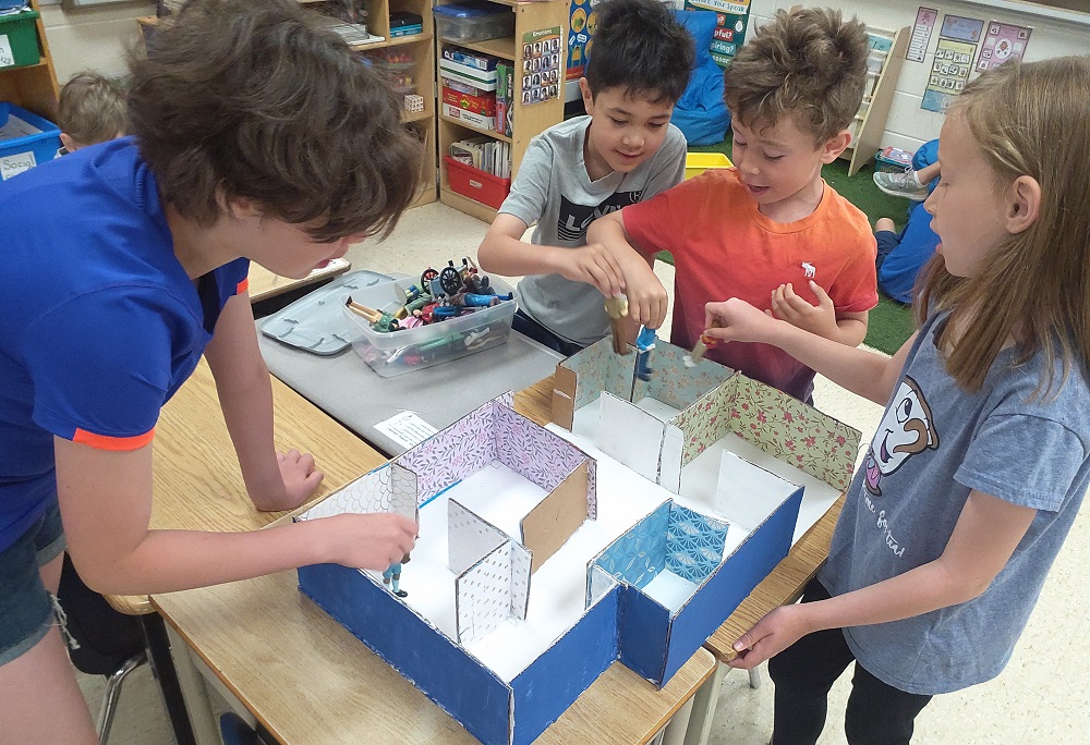 A group of children in a PLASP program build a structure together 